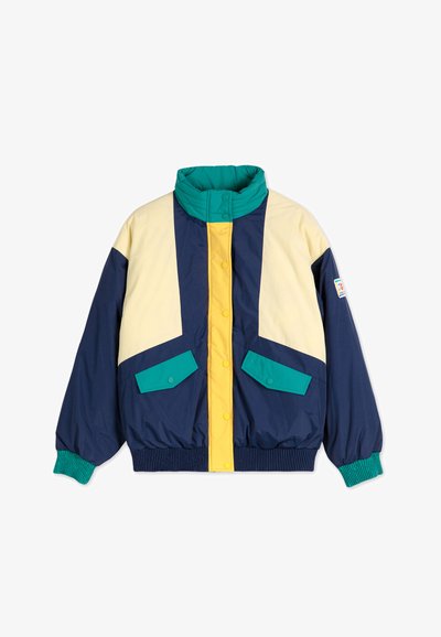 Veste en duvet colorée avec des sections bleu marine, jaune et sarcelle, col haut, fermeture à boutons-pression et poignets côtelés, ainsi que deux poches avant.