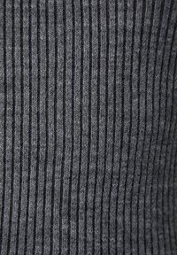 Hallideeritud hall kangas, millel on vertikaalne soonikute muster, sisaldades erinevaid toone ja pehmet tekstuuri. Silmapaistvad õmblused loovad peene sügavuse.