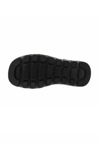 Zwarte rubberen zool met een gestructureerd rasterpatroon met rechthoekige en vierkante inkepingen voor grip en tractie.