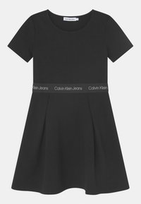 Černé šaty s krátkým rukávem a přiléhavým tělem, rozšířenou sukní a páskem s logem Calvin Klein Jeans, vyrobené z hladkého materiálu.