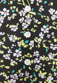 Black fabric with a floral pattern in white, light pink, and green. Features white buttons along the front placket. Soft, textured finish.