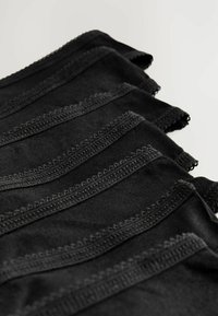 Des sangles en tissu noir disposées en couches, présentant une texture lisse avec des bords festonnés et des détails de couture contrastants.