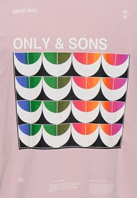 Camiseta de color rosa claro con un gráfico geométrico que presenta semi-círculos de colores verde, azul, naranja y rosa. El texto incluye "ONLY & SONS" y "SINCE 2013."