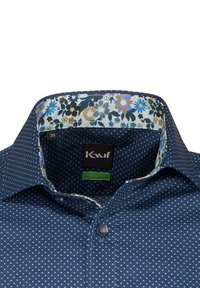 Camicia blu a pois con colletto foderato in stampa floreale. Presenta un colletto classico e chiusura con bottoni. Tessuto strutturato. Etichetta della taglia visibile.