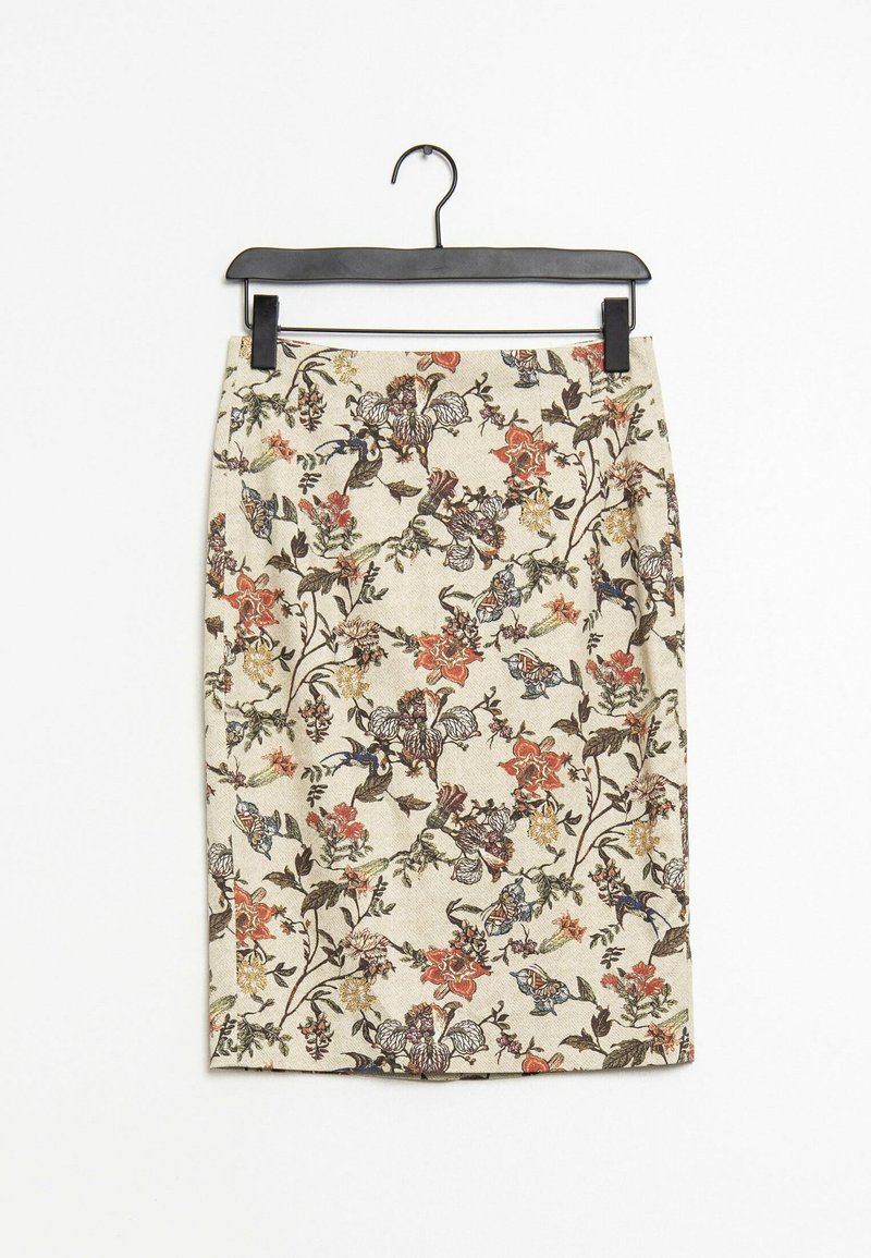Jupe crayon florale arborant un fond crème avec des motifs multicolores de fleurs et d'oiseaux, réalisée en tissu texturé, suspendue à un cintre noir.