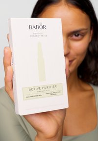 Die Babor Active Purifier Box in hellem Creme enthält ein grünes Etikett. Sie enthält sieben 2 ml Ampullen für ölige, zu Akne neigende Haut.