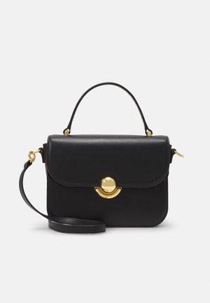 Sac à main en cuir noir au design structuré, avec des ferrures circulaires en or, une poignée supérieure et une bandoulière amovible. Texture lisse.