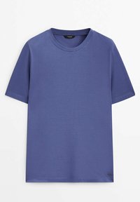 T-shirt bleu uni à manches courtes et col rond, avec une petite étiquette de marque noire près de l'ourlet inférieur sur le côté droit devant.