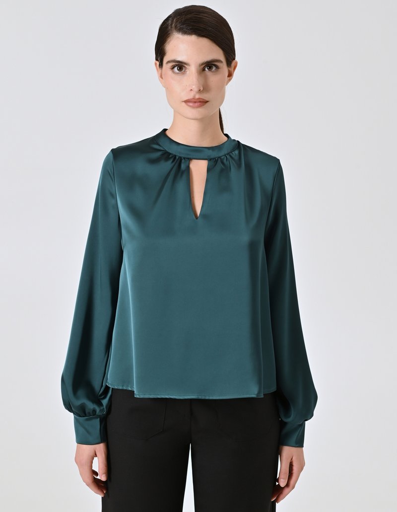 Blusa di raso teal con maniche lunghe e scollatura a chiave. Presenta una texture liscia e dettagli arricciati sulle spalle.