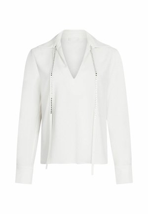 Blouse blanche à manches longues avec un col noté, présentant des détails en argent texturé le long de l'encolure et une coupe droite et décontractée.