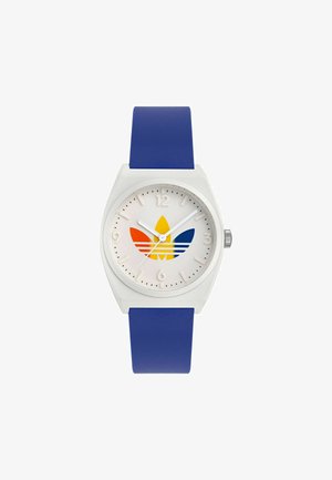 Montre en plastique blanc avec un bracelet en silicone bleu. Présente un cadran blanc et un design de logo trèfle multicolore (jaune, orange, bleu).