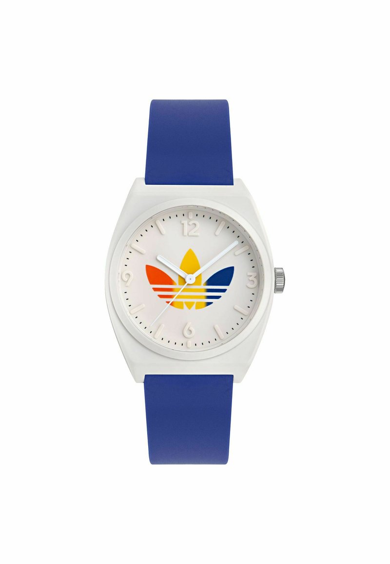 Bela plastična ura z modrim silikonskim trakom. Ima bel številčnik in večbarvni logotip v obliki trefoila (rumena, oranžna, modra).
