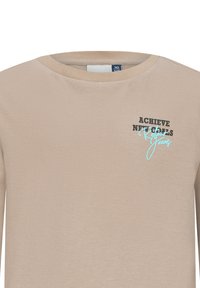 Camicia beige a maniche lunghe con collo a giro. La scritta stampata in nero e azzurro chiaro dice "RAGGIUNGI NUOVI OBIETTIVI" e "Jeans". Materiale in cotone morbido.