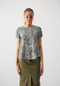 Top verde cu mânecă scurtă, cu un model paisley, având designuri florale complexe în nuanțe de bleumarin și bej. Material texturat cu un guler rotund.