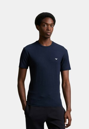 T-shirt en jersey côtelé bleu marine à manches courtes avec un col rond et un petit logo sur la poitrine; fabriqué en tissu texturé.