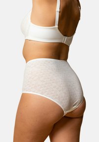 Culotte blanche taille haute avec motif géométrique texturé. Tissu doux et extensible avec une finition lisse et une large ceinture pour un confort optimal.