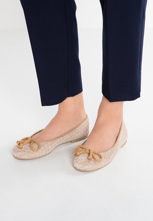 Beżowe baletki z plecionego materiału, zaokrąglonym noskiem i ozdobionym kokardą z liny, posiadające płaską podeszwę i gładką fakturę.