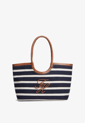 Navyblauwe en witgestreepte totebag met bruine gevlochten handvatten en leren afwerking, met bruine cursieve initialen "FH" aan de voorkant.