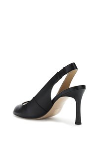 Scarpa slingback in pelle nera con punta aperta, tacco sottile e cinturino elastico per una migliore vestibilità. Texture liscia con un design minimalista e colore naturale.