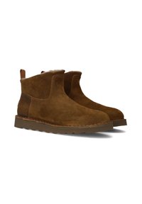 Suède enkellaarzen in donkerbruin met een soepele textuur, elastische zijkanten, een trekband en een dikke rubberen zool. Geen zichtbare patronen.