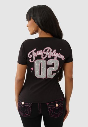 Zwarte t-shirt met "True Religion" in glinsterend roze en zilver, met het nummer "02" in rhinestones. Korte mouwen en een ronde hals.