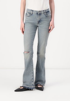 Light blue flared jeans with distressed knee detail and frayed hem. Made from denim, featuring a classic 5-pocket design and subtle wash.