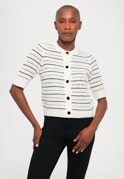 Witte short-sleeve cardigan met zwarte horizontale strepen en open breipatronen, met zwarte knopen aan de voorkant.