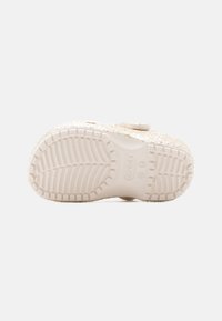 Λευκή σόλα παπουτσιού με υφή και σχέδιο για καλύτερη πρόσφυση, που διαθέτει μικρό λογότυπο και γκλίτερ επάνω στην άκρη. Ομαλ ό υλικό με ελαφριά γυαλάδα.