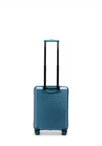Tvrdý kufr v tyrkysové barvě s žebrovanou texturou, vysouvací černou rukojetí a čtyřmi kolečky pro snadnou mobilitu.