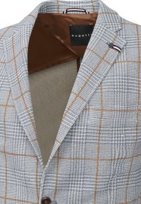 Hellblaues Blazer mit Karomuster. Verfügt über braune Akzente, Reverskragen und ein braunes Innenfutter. Markenetikett innen sichtbar.