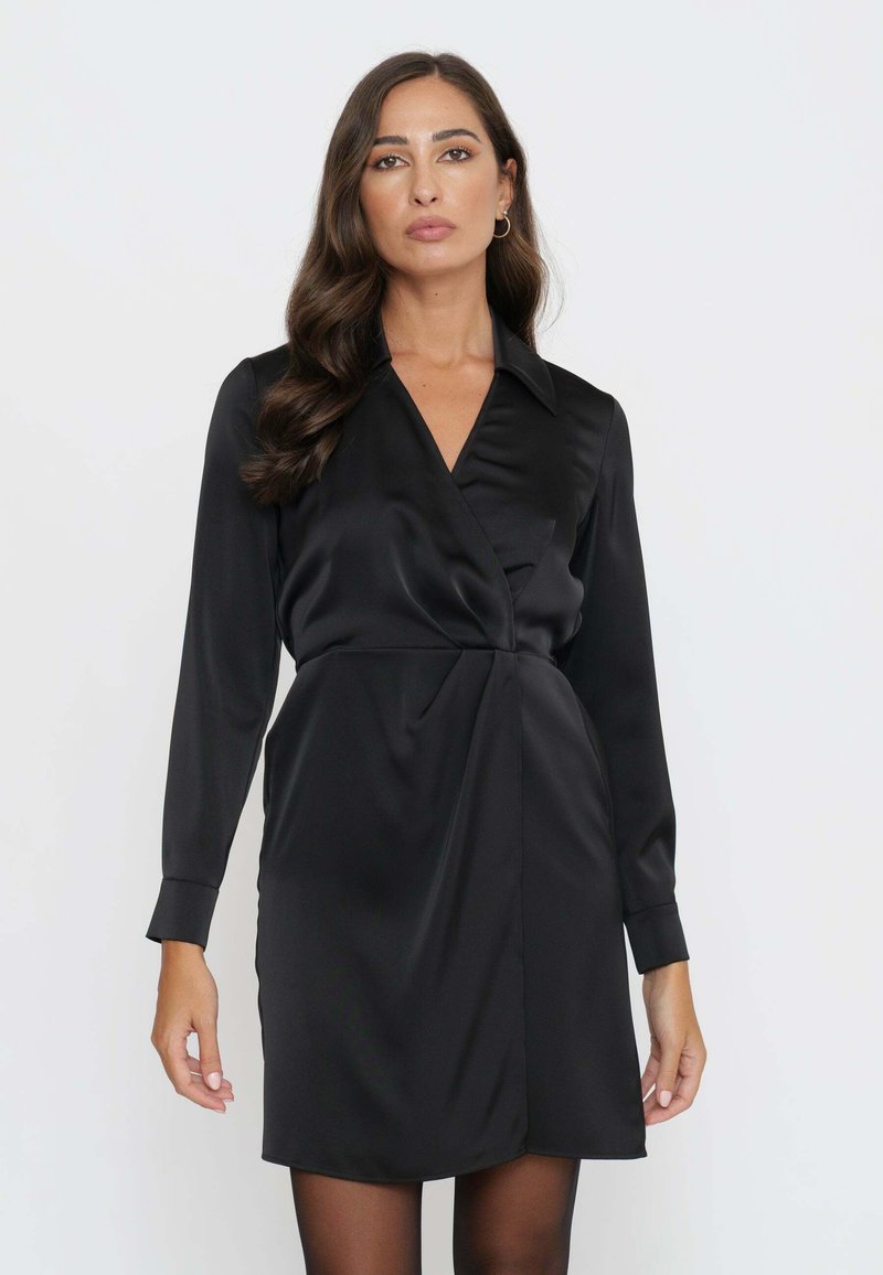 Abito avvolgente in satin nero con maniche lunghe, colletto e silhouette aderente, caratterizzato da uno spacco laterale e una texture liscia.