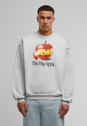 Light gray sweatshirt featuring a large graphic of a smiling apple with a yellow band and text "The Big Apple" below in black.