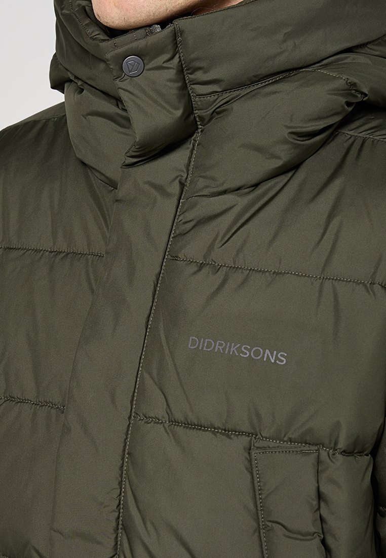 Olivgrüne isolierte Jacke mit hohem Kragen, Knopfverschluss und sichtbarem Logo auf der Brust, ausgestattet mit horizontalen Nähten und einer Tasche.