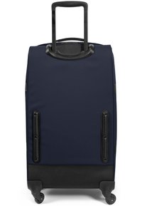 Maleta de tela azul marino con asa telescópica, acentos en negro, patas de plástico y ruedas suaves para una fácil movilidad.