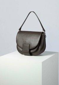 Borsa a mano in pelle marrone scuro con chiusura a patta curva, una cinghia frontale e un manico corto per la spalla. Texture liscia, design minimalista.