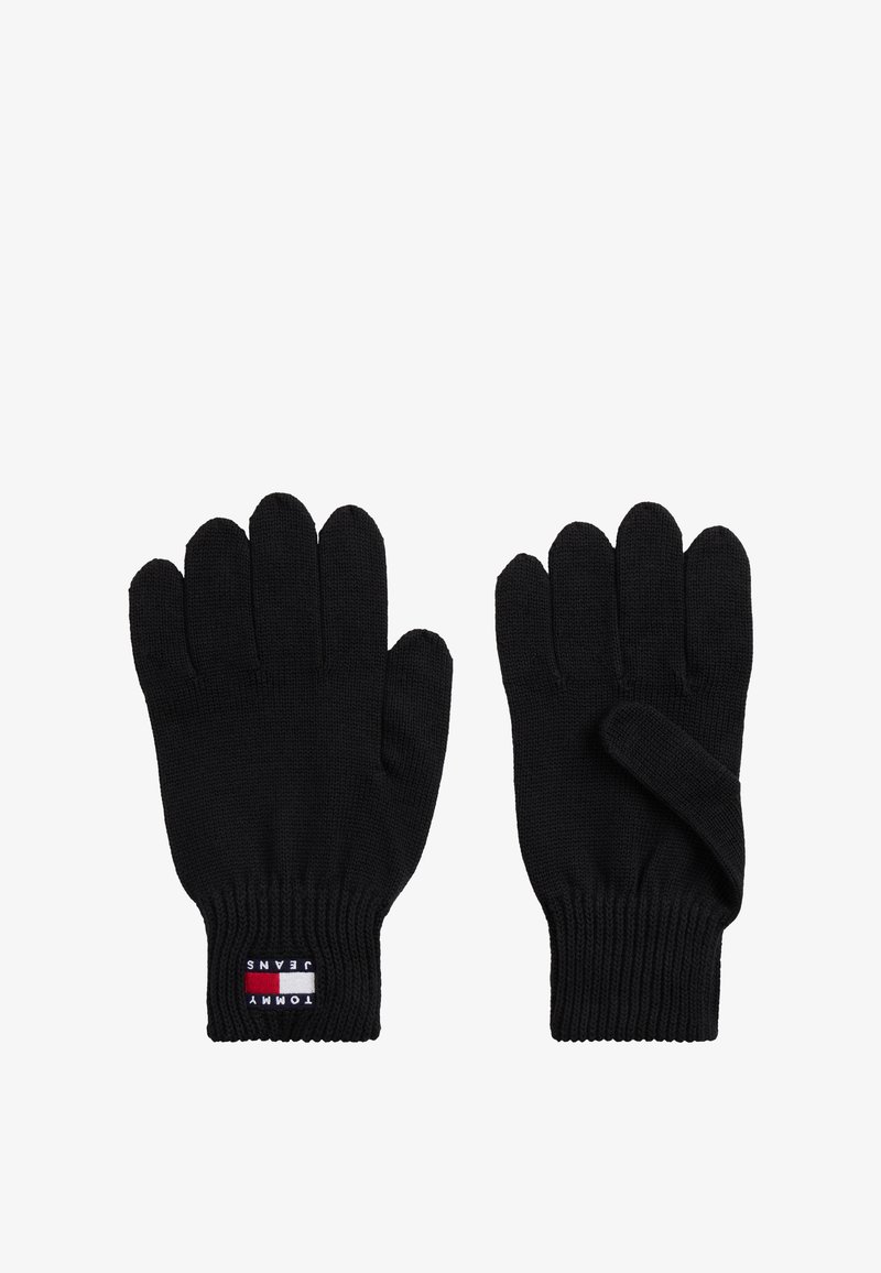 Gants en maille noirs avec poignets côtelés, l'un présente un patch logo Tommy Jeans sur le poignet, affichés sur un fond blanc.