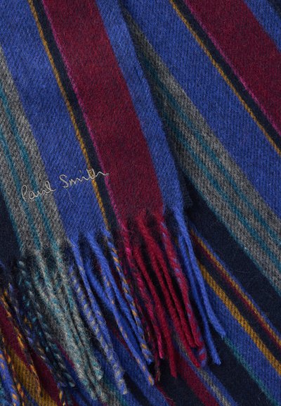 Κασκόλ από μάλλινο ύφασμα με έντονες ρίγες σε κόκκινο, μπλε, γκρι και κίτρινο, με λεπτομέρειες κρόσσια και κεντημένο το "Paul Smith" σε ασημί.