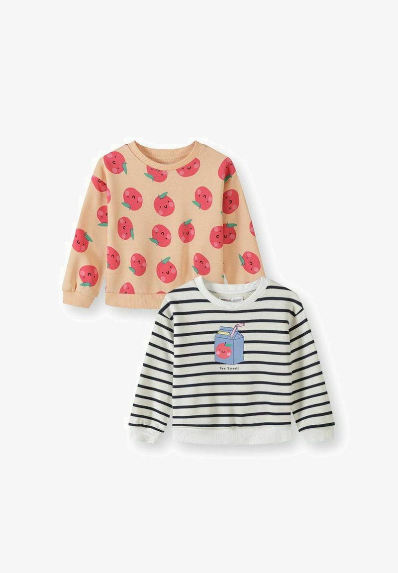 Deux hauts à manches longues pour enfants : un pêche avec un motif de fruits souriants rouges, un blanc avec des rayures noires et un motif de boîte de jus souriante.