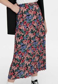 Gonna plissettata floreale con sfondo nero, decorata con fiori rosa, rossi e blu. Vita elastica e tessuto leggero.