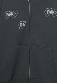 Szürke, cipzáras kapucnis pulóver két első zsebbel, hímzett fehér logókkal a mellrészen, sima, puha tapintású anyagból.