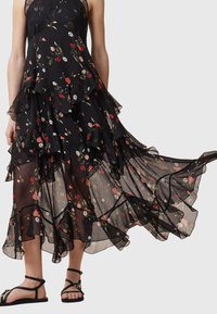 Black floral dress with layered ruffles, featuring red and white flower patterns, sheer lightweight fabric, and a lace bodice.