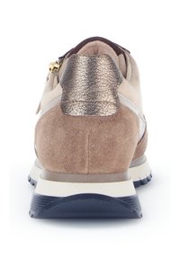 Beige suede sportieve schoen met een metalen accent op de hiel. Heeft een gevoerde zool en een getextureerde donkerblauwe rubberen buitenzool voor grip.