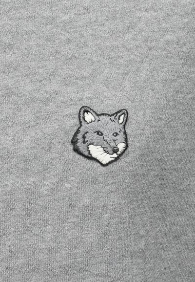 Felpa grigia con un emblema ricamato a forma di testa di volpe grigia con accenti bianchi, posizionato sul lato sinistro dell'area del petto.