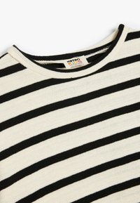 Sorte og hvide stribede børnesweater med rund halsudskæring, ribbet struktur og et mærke med teksten "Koton Kids."