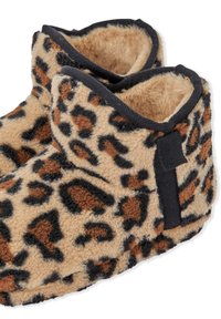 Chaussons en polaire douce avec un imprimé léopard marron et noir, un bord noir, et une petite boucle noire au talon pour un enfilage facile.
