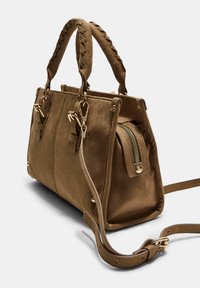 Sac à main en daim marron avec poignées tressées, accents en doré, poche zippée à l'avant et bandoulière amovible. Design structuré.