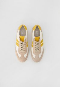 Sneaker beige e bianche con accenti gialli, materiali scamosciati e sintetici, punta rotonda, design con lacci e strisce in contrasto.