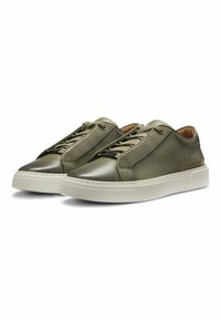 Olive green leather sneakers with a smooth texture, featuring a rounded toe, white rubber sole, and matching laces. Accented stitching detail.