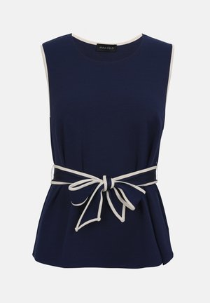 Μπλε ναυτικό τοπ χωρίς μανίκια με λευκή επένδυση στις άκρες και έναν ταίριαστο λευκό φιόγκο με επένδυση δεμένο στη μέση.