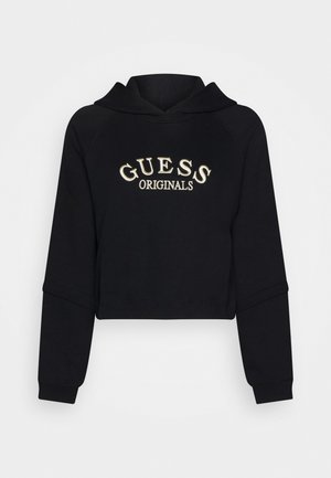 Czarna krótka bluza z kapturem z haftowanym na przodzie białym napisem "GUESS ORIGINALS", z długimi rękawami i kapturem.